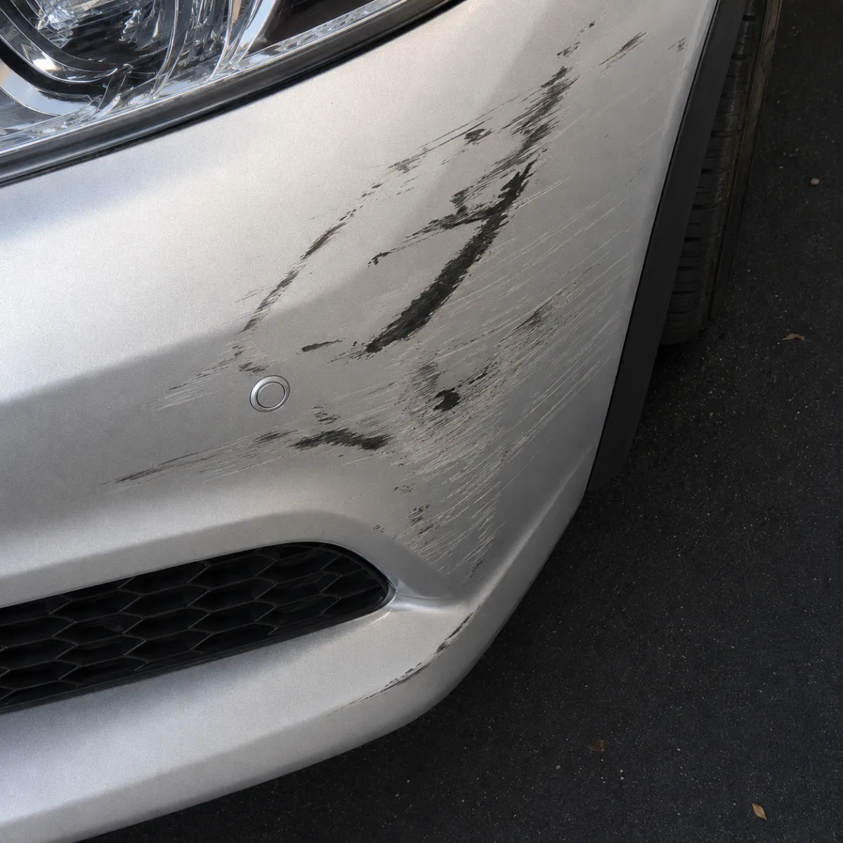 Before, a scuffed, scratched car bumper